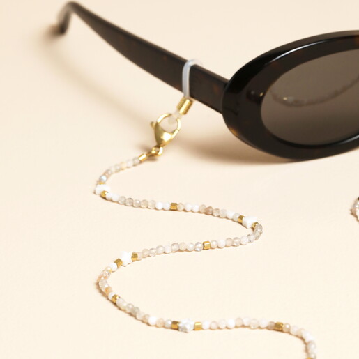 Close-up of white faceted stone beads and star charms on glasses chain
