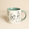 Off white stoneware mug with black cat illustrations and a sage green handle