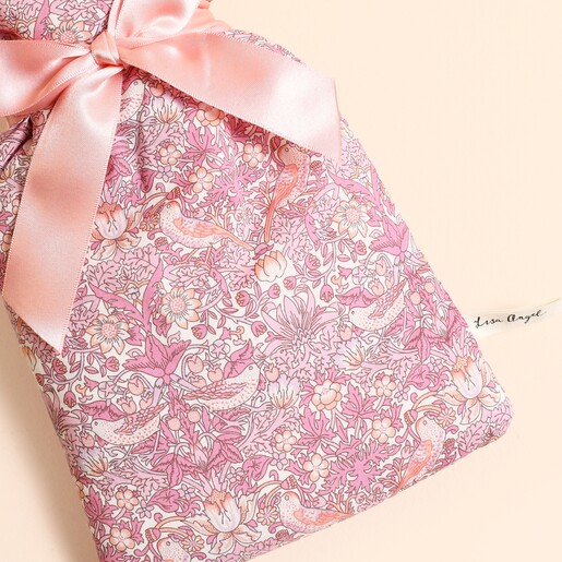 Close up of pink Strawberry Thief patterned cotton cover and satin bow tie