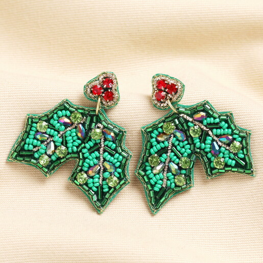 A Pair of Green Fabric Drop Earrings Adorned With Green and Red Crystals and Beads on a Neutral Background
