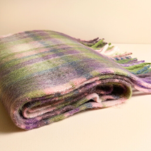Close-up of folded soft purple and green tartan winter scarf