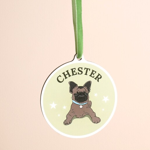 Close-up of personalised circular dog decoration with French bulldog illustration and green ribbon.