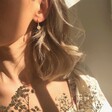Lisa Angel Daisy Charm Huggie Hoop Earrings in Gold on Model