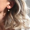 Model Wearing Lisa Angel Daisy Charm Huggie Hoop Earrings in Gold