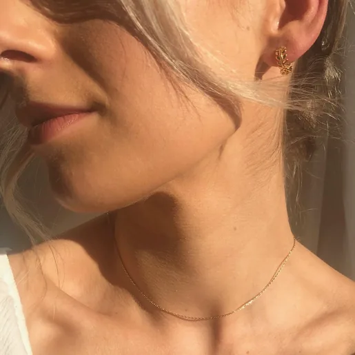Model is wearing Lisa Angel Ladies Fern Leaf Huggie Hoop Earrings in Gold