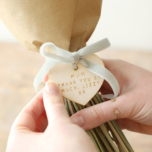 model holding personalised token on dried flower bouquet that reads mum thank you so much. lizzy xx