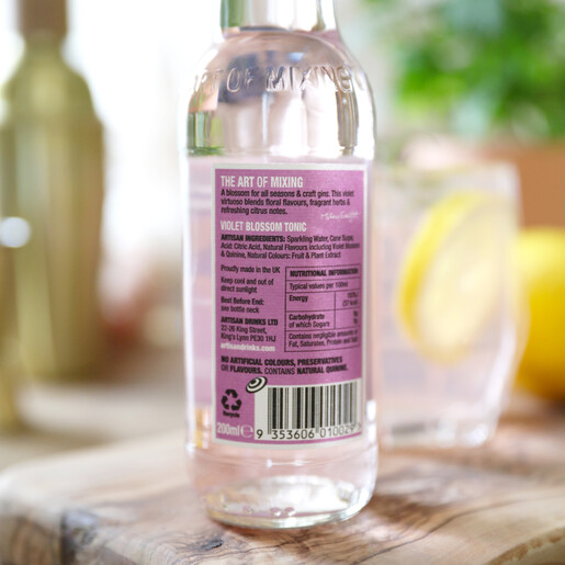 ingredients list of artisan drinks co violet blossom tonic with plant, cocktail shaker and glass in background