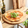 Pizza on Round Olive Wood Pizza Board on Kitchen Worktop