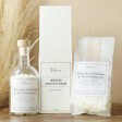 The Annex Sea Samphire and Watermint Pearls bottle, diffuser and bag on a brown table in front of pampas grass
