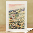 Sunset Flower Field Greeting Card on Table