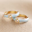 Baby Blue Enamel Crystal Huggie Hoop Earrings in Gold on Beige Fabric