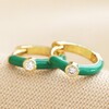 Green Enamel Crystal Huggie Hoop Earrings in Gold on Beige Fabric