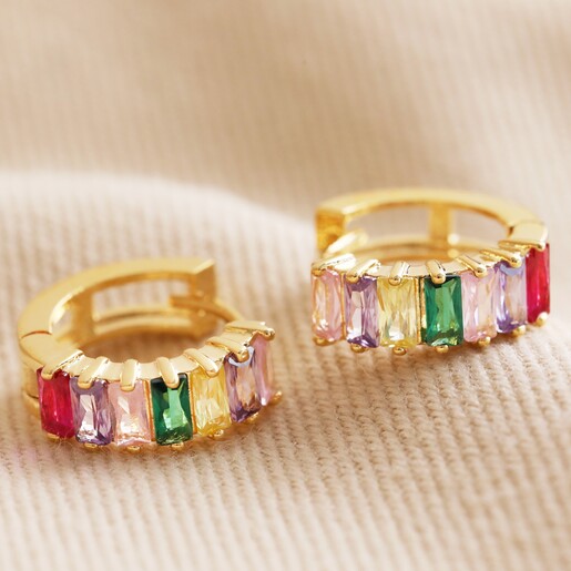 Pink and Green Baguette Crystal Huggie Hoop Earrings on Beige Fabric