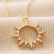 Crystal Sunburst Pendant Necklace in Gold on Beige Fabric