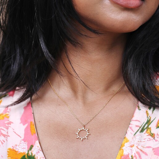 Close Up of Model Wearing Crystal Sunburst Pendant Necklace in Gold