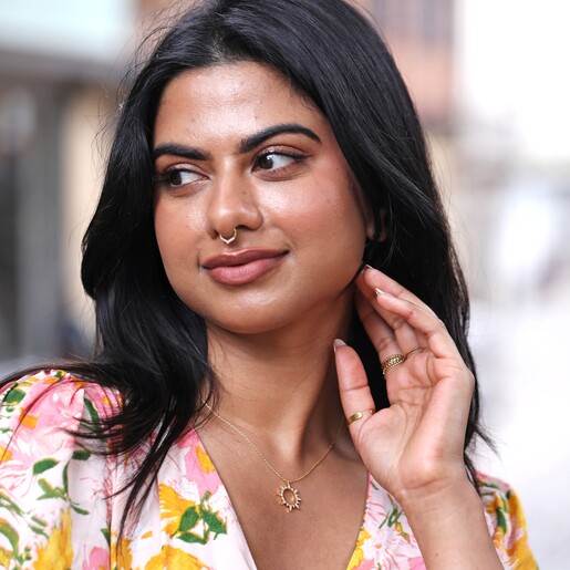 Model Wearing Crystal Sunburst Pendant Necklace in Gold