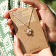 Model Holding Large Flower Pendant Necklace with Pearl in Gold on Card