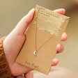 Model Holding Opal Moon Charm Necklace in Gold on Packaging