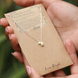Model Holds Organic Hammered Droplet Charm Necklace in Silver on Card