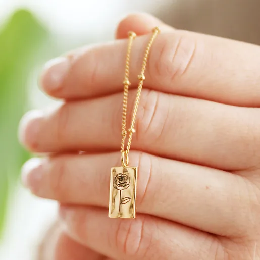 Model Holding Personalised Birth Flower Tiny Tag Pendant Necklace