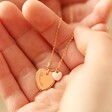 Model Holding Personalised Tiny Enamel Heart Necklace in Pale Pink