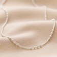 Silver Satellite Chain Necklace on Beige Fabric