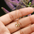 Model Holding Tiny Butterfly Pendant Necklace in Gold