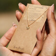 Model Holding Tiny Butterfly Pendant Necklace in Gold on Card