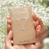 Model Holding Tiny Butterfly Pendant Necklace in Silver on Card