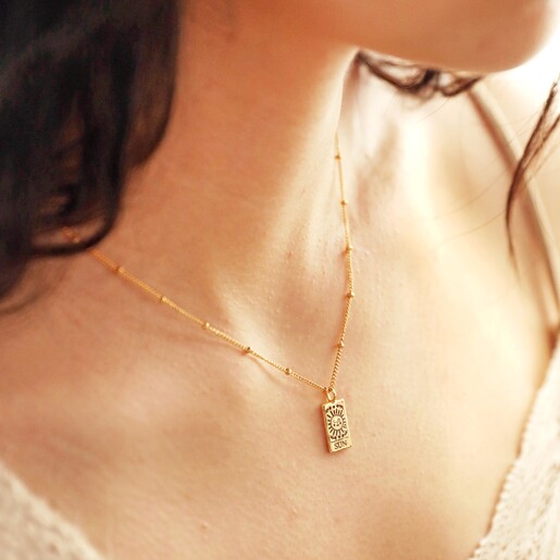 Close Up of Tiny Hammered Tarot Card Pendant Necklace on Model