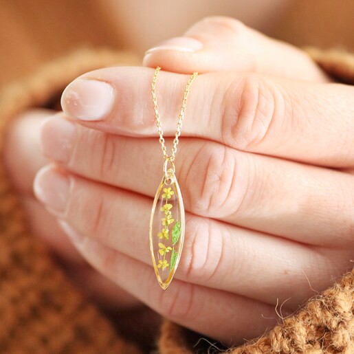 Model Holding Pressed Yellow Flowers Pendant Necklace in Gold