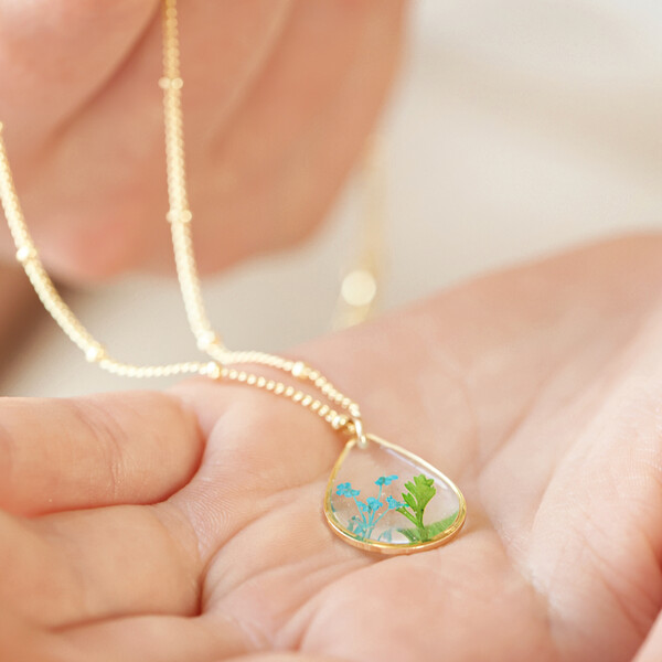 Model holding Real Pressed Flower Pendant Necklace in Gold in palm of hand