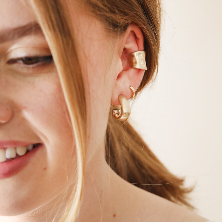 Model wearing curated ear look with gold jewellery and Wide Organic Finish Ear Cuff