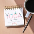 Daily Yoga Poses Flip Chart on Table with Pen and Cup of Coffee
