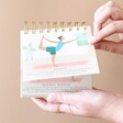 Model Turning Pages of Daily Yoga Poses Flip Chart