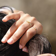 Model's Hand in Hair Wearing Big Metal London Set of 8 Adjustable Crystal Rings in Gold