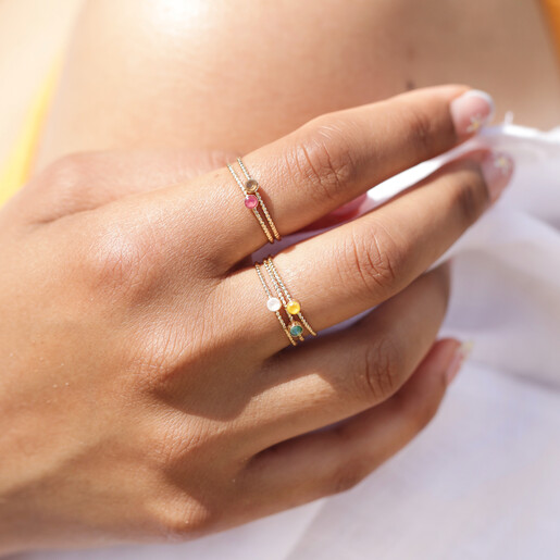 Close Up of Hand with Big Metal London Set of 8 Adjustable Crystal Rings in Gold