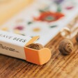 open packaging of Beevive Bamboo Bee Revival Kit Keyring in Gold containing seedballs