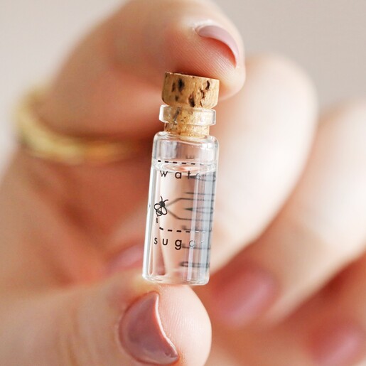 model holding bottle of syrup in Beevive Bamboo Bee Revival Kit Keyring in Gold