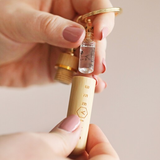 model taking syrup bottle out of Beevive Bamboo Bee Revival Kit Keyring in Gold