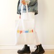 model holding Personalised Rainbow Cotton Tote Bag in White by the straps