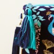 close up of zip tassel on House of Disaster Luxe Peacock Clutch