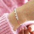 model wearing Estella Bartlett Pastel Rainbow Cord and Stars Bracelet  and using pull fastening
