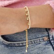 Close up of Estella Bartlett Woven Star Charm Bracelet in Gold on model