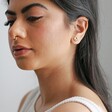 Model wearing Estella Bartlett Gold Pearl Buttercup Stud Earrings