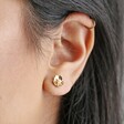 Close up of model wearing Estella Bartlett Gold Pearl Buttercup Stud Earrings