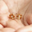 Model holding Estella Bartlett Gold Pearl Buttercup Stud Earrings
