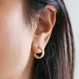 close up of Estella Bartlett Woven Hoop Earrings in Gold on model