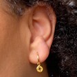 Close Up of Model Wearing Gold Sterling Silver Star Disc Charm Huggie Hoop Earrings