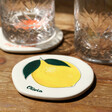 Personalised Lemon Fruit Organic Shape Coaster on Wooden Table with Glasses in Background